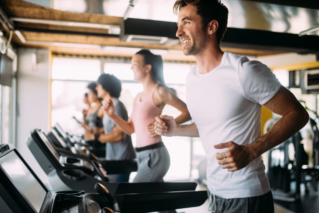 Happy group of sportive people in a gym. Concepts about lifestyle and sport in a fitness club